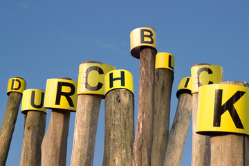 Text Durchblick auf Holzpfeiler mit Himmel im Hintergrund