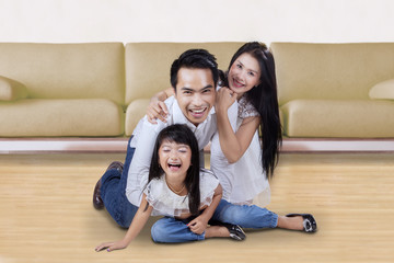 Joyful family playing together on the floor