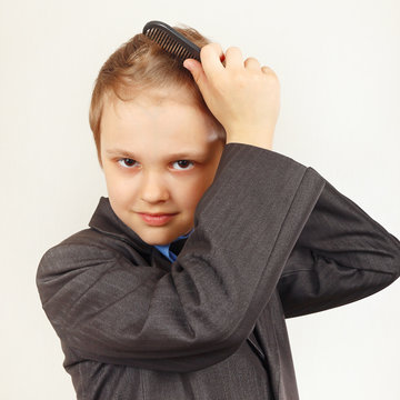 Little Stylish Boy In A Business Suit Brushing Her Hair A Hairbrush