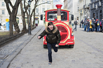 Obraz premium Man with a laugh escapes from the red train