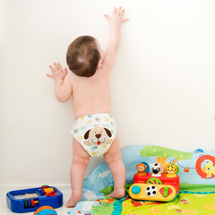 baby stretches his hand up on a white background