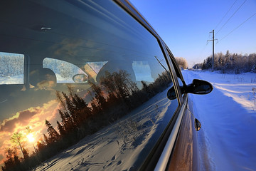 car at sunset in winter landscape