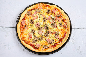 Delicious pizza with mushrooms and ham.