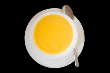 Top view of soup served in a white bowl and plate with spoon
