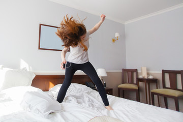 Woman listen to rock music and head bang on bed