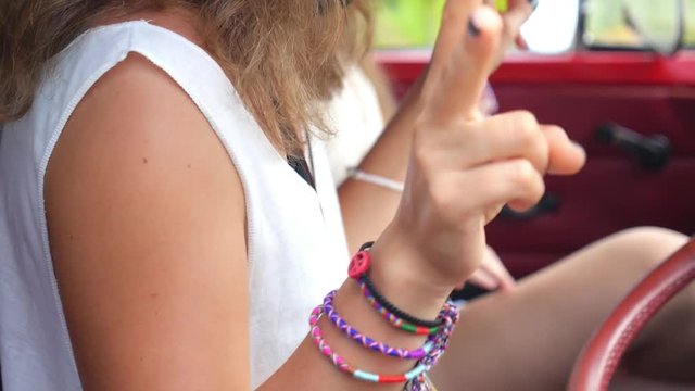 Hippie Girl Dancing Inside Retro Minivan Showing Peace Sign