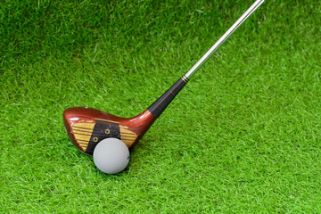 Old golf club and golf ball on green grass background.Outdoor sport concept.