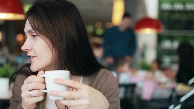 girl drinking coffee and talking to someone
