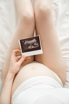 Young pregnant woman looking at ultrasound scan
