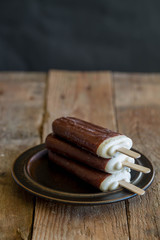 popsicle with grated chocolate on a wooden background