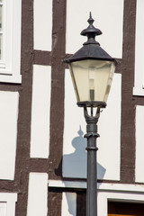 Fototapeta na wymiar Straßenlampe vor Fachwerkfassade in Rheda, Nordrhein-Westfalen
