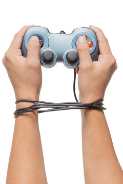 Hand Holding Game Controller And Tied Up With Cables Isolated On