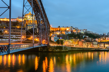 the waterfront of the river Douro and Dom Luis I bridge at night, Porto, Portugal.