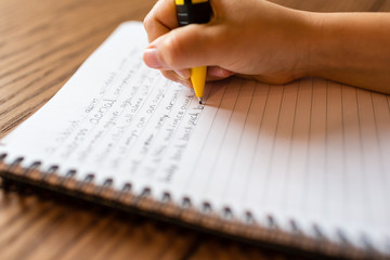Person writing by hand on notepad