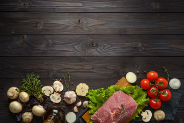 raw meat with ingredients on a wooden background