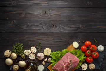 Photo sur Plexiglas Viande raw meat with ingredients on a wooden background
