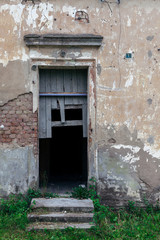 Decayed entrance with broken doors to an abandoned building