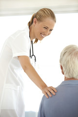 Obraz premium Beautiful young female doctor talking to senior patient