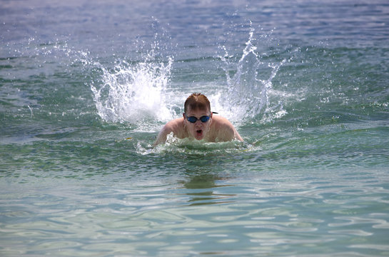  young sporting man swims in the sea