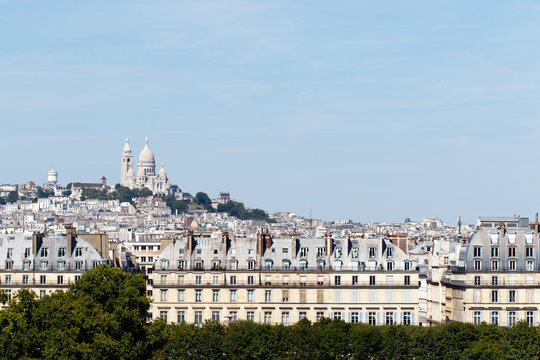 Color DSLR stock image of Basilica of the Sacre Coeur on Montmartre, Paris, France with the capital cityscape in the foreground. Horizontal with copy space for text