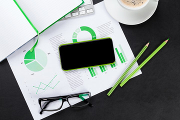 Office desk with phone, charts and coffee