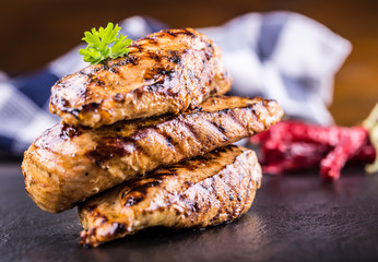 Grilled chicken breast in different variations with cherry tomatoes, .mushrooms, herbs, cut lemon on a wooden board or teflon pan. Traditional cuisine. Grill kitchen.