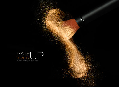 Fototapeta Cosmetics brush with glowing face powder. Dust explosion
