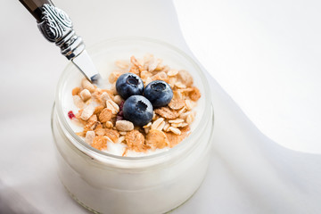 Healthy breakfast - yogurt with blueberries and muesli served in bank