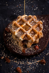 Belgian sugar waffles with grated nuts and caramel syrup