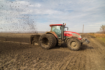 Tractor with double wheeled ditcher digging drainage canal