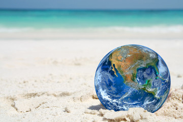 the earth on beach, including elements furnished by NASA