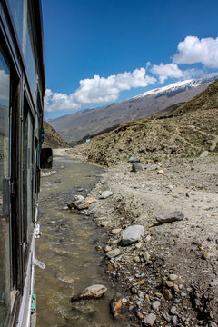 A Bus On A Very Bad Road, With Water Flowing, On The Popular Highway, For Tourism, Between Manali, Himachal Pradesh To Leh, Ladhak, Jammu & Kashmir In India 