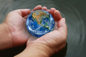 two hand hold the earth on water ,including elements furnished b