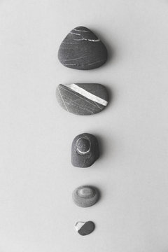 Lined up pebbles in black and white on a white background