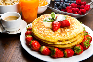 stack of freshly prepared traditional pancakes with strawberries