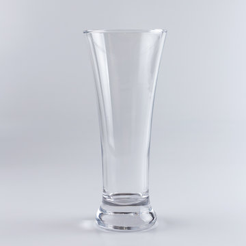 Empty beer glass against white background