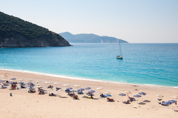Fototapeta na wymiar Sunbeds and umbrellas on the Myrtos beach