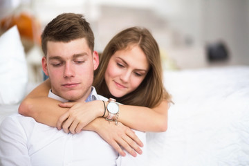 Fototapeta premium Happy girl in love at home embracing boyfriend