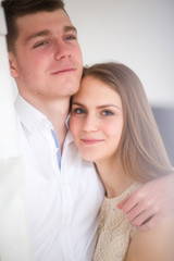 Happy woman dressed in  shirt put her head on shoulder of man