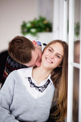 Happy young man kissing his girlfriend in the neck