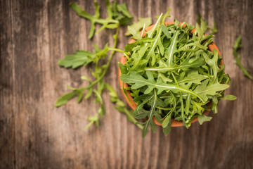 Fresh juicy arugula on wooden background and copy space