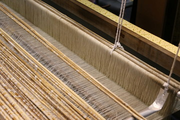 Close up of gold silk weaving on loom - 107711663