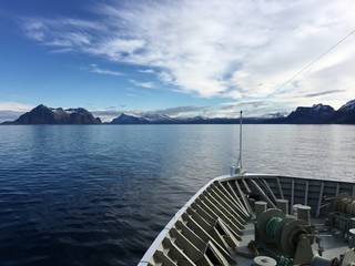 Hurtigruten/Norwegian Coastal Express in beautiful landscape in Nordland, Norway. The coast here is known for its fabulous mountains and islands, many of them are over 500-metres above sea level.