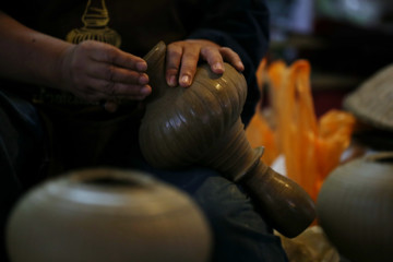 Hands working on pottery - 107712238