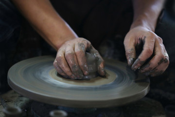 Hands working on pottery wheel