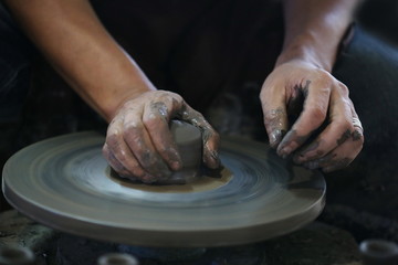 Hands working on pottery wheel