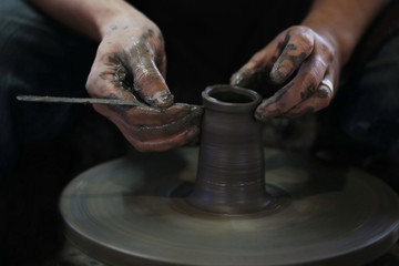 Hands working on pottery wheel - 107712279