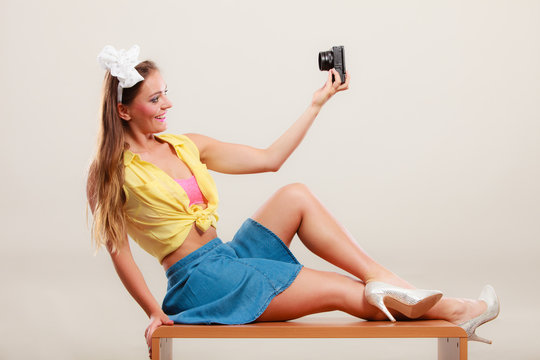 Pin up girl woman taking photo with camera.