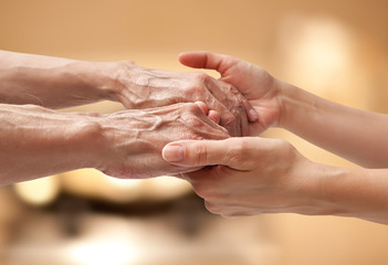 Fototapeta premium Female hands touching old male hand