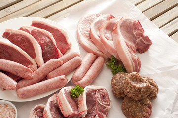 Wooden table set with selection of meat cuts